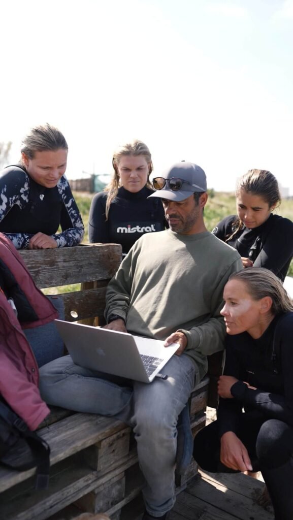Surfers reviewing technical video analysis during a high-performance coaching session with Filipe Anjos in Baleal, Portugal.