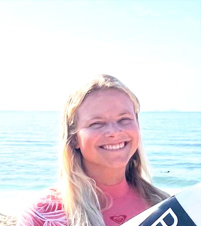 Mirna from the Netherlands smiling with her surfboard after an intensive small group surf coaching session in Peniche with Filipe Anjos.