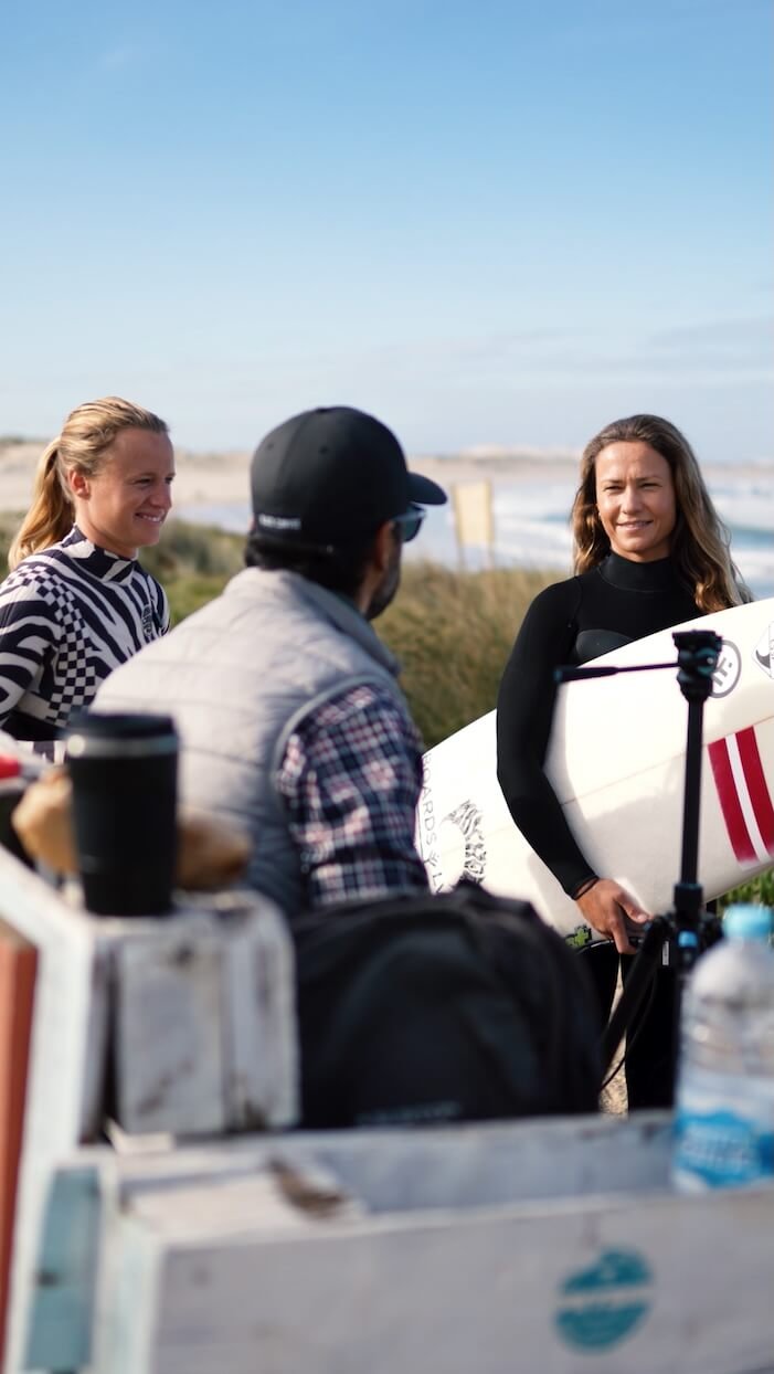 Filipe Anjos conducting a technical briefing with private clients before a surf session in Peniche, focusing on personalized goals.