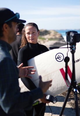 Filipe Anjos providing a tailored technical briefing to a private surf client on the beach in Peniche, focusing on specific progression goals.