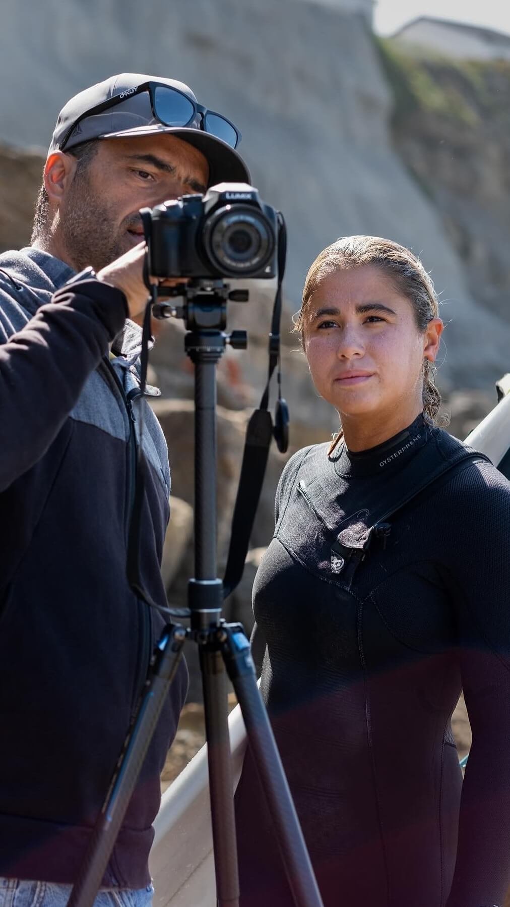 Professional surf coach Filipe Anjos using a tripod and camera for high-quality video analysis during a technical surf coaching clinic.